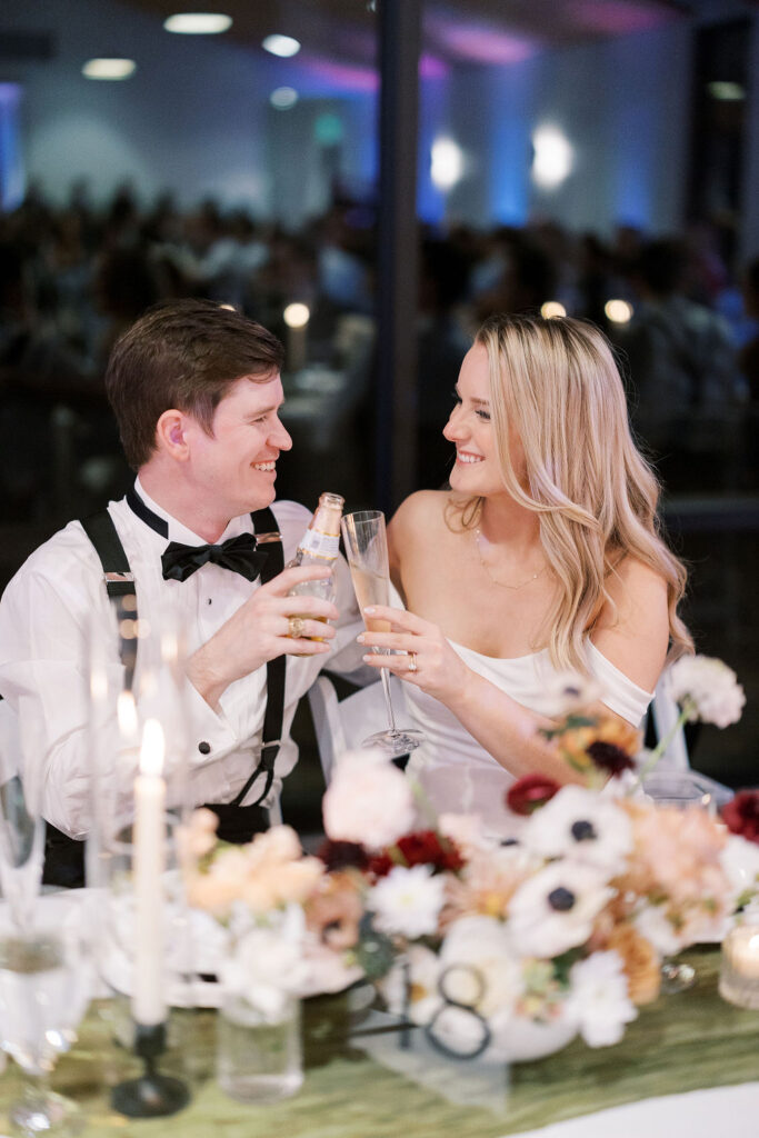 A sweet couple sharing a champagne toast on their wedding day in Austin, TX.  Check out this list of Valentine's Day Dates Engaged Couples love!  For stress-free wedding planning, visit www.momentsbymaddie.com!