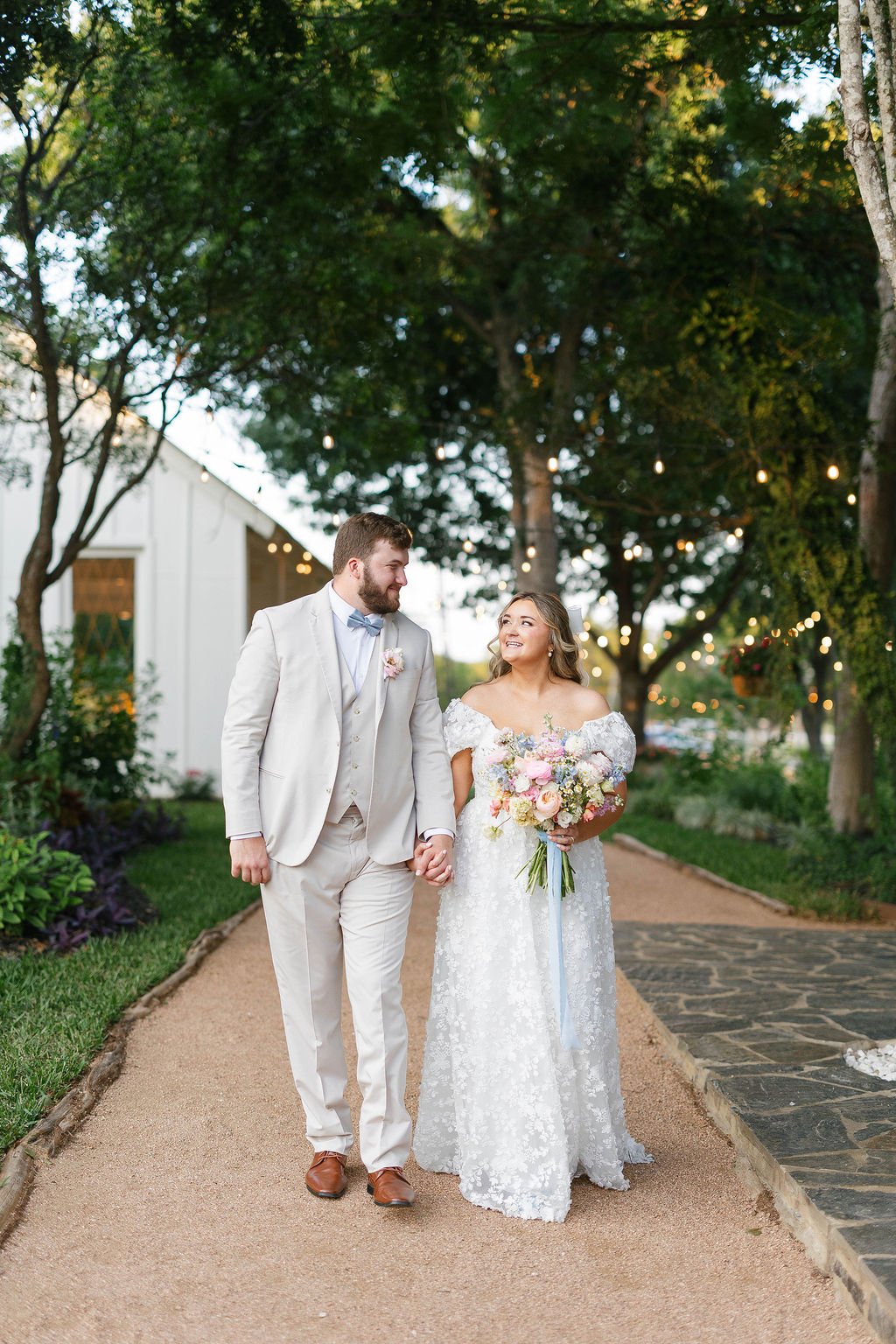 Bride and groom walking outside their wedding venue holding hands, showcasing a smooth and joy-filled day planned with support from a wedding coordinator.
