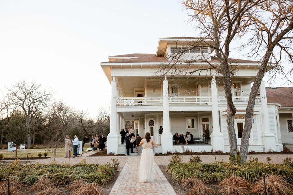 Guests mingling outside The Grand Lady wedding venue during a fall wedding in Texas