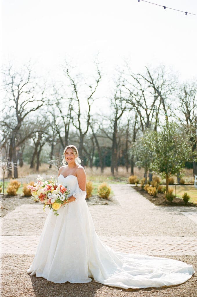 Bride holding a colorful bouquet before an outdoor fall wedding in Texas